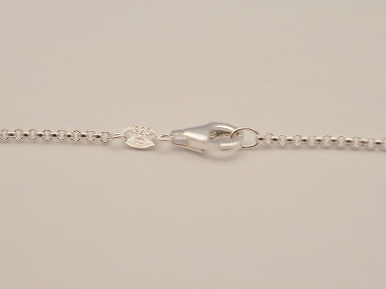 Op de afbeelding: Een zilveren ketting met een karabijn sluiting en een 925 stempel.