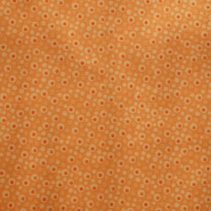 Könnte beinhalten: Orangener Stoff mit weißem Punkte-Muster. Der Stoff hat eine subtile Textur.