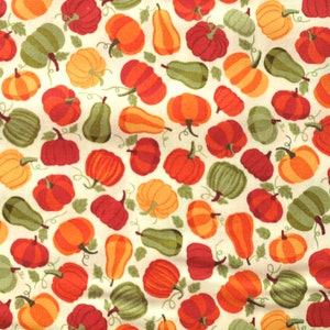 Peut inclure: Un tissu blanc avec un motif répété de citrouilles orange, rouge et verte. Les citrouilles sont de formes et de tailles variées.