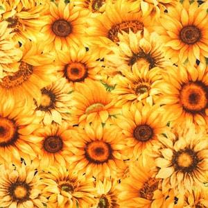 Op de afbeelding: Een close-up afbeelding van een stof met een herhalend patroon van gele zonnebloemen. De zonnebloemen zijn in een willekeurig patroon gerangschikt en kijken allemaal naar de kijker. De stof is donkerblauw.