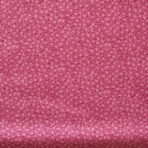 Può includere: Un tessuto rosa con un piccolo motivo floreale bianco.