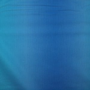 Könnte beinhalten: Nahaufnahme eines blauen Stoffes mit Farbverlauf. Die Farbe geht von einem helleren Türkis in ein tieferes, satteres Blau über. Der Stoff scheint eine subtile Textur zu haben.