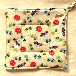 Può includere: Un sottopentola beige con un motivo di camper vintage colorati. Il sottopentola ha un'impugnatura ad anello ed è trapuntato.
