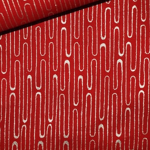 Può includere: Tessuto rosso con un motivo metallico argentato di linee verticali e curve.