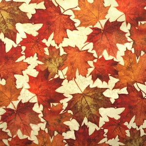 Könnte beinhalten: Ein Muster aus Herbstahornblättern in Rot-, Orange- und Brauntönen. Die Blätter sind auf einem cremefarbenen Hintergrund verstreut und schaffen ein warmes und einladendes Herbstthema.