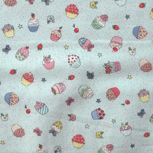 Könnte beinhalten: Hellblauer Stoff mit einem sich wiederholenden Muster aus Cupcakes, Erdbeeren, Kirschen, Blumen, Schleifen und Sternen. Die Cupcakes haben verschiedene Farben und Designs, mit Zuckerguss und Belägen.
