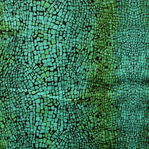Op de afbeelding: Een stof met een groen en blauw mozaïekpatroon. Het mozaïekpatroon bestaat uit kleine, onregelmatige vormen die lijken op schubben.