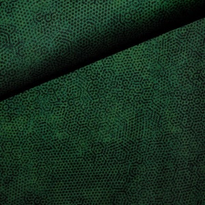 Op de afbeelding: Close-up van een donkergroene stof met een textuurpatroon van kleine, herhalende cirkels.