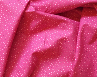 May include: Pink fabric with a white polka dot pattern. The fabric is folded and textured.