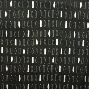 May include: A black fabric with a white geometric pattern of various shapes, including rectangles, ovals, and diamonds.