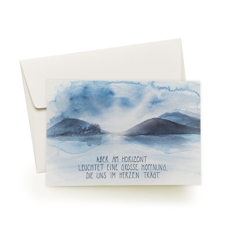 May include: A watercolor painting of a landscape with two mountains and a body of water. The sky is blue with white clouds. The text reads "Aber am Horizont leuchtet eine grosse Hoffnung, die uns im Herzen tr&auml;gt."