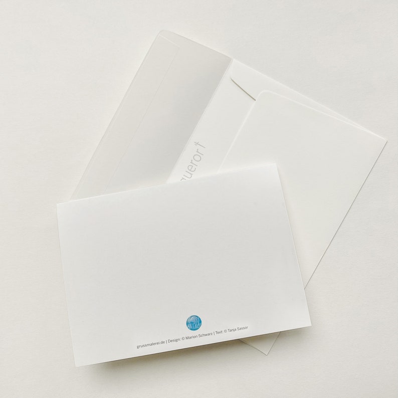 May include: A white card with a blue circle on the back. The circle has a design of a wave and the text "grussmalen.de | Design: &copy; Marion Schwarz | Text: &copy; Tanja Seisser".