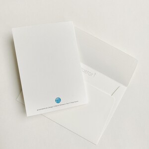 May include: A white envelope with a white card inside. The card has a blue circle with a design of a building on it. The text on the card reads "grussatelier.de | Design: &copy; Marion Schwarz | Text: &copy; Tanja Sassor".