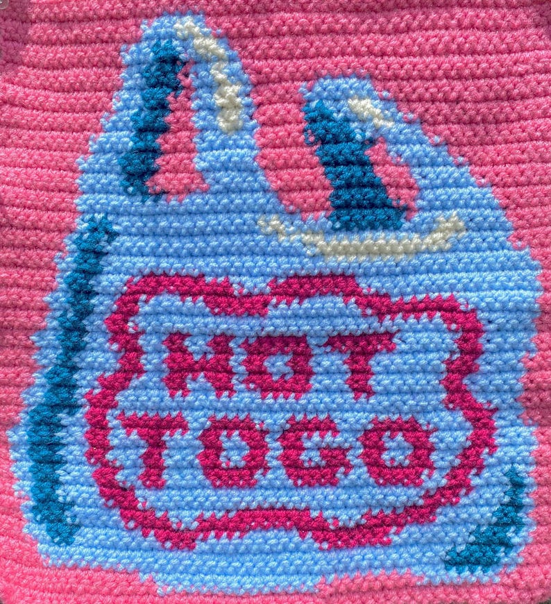 K&ouml;nnte beinhalten: Ein handgefertigtes, geh&auml;keltes Objekt mit einem hellblauen Taschen-Design mit einem rosa Rand und den Worten "HOT TOCO" in Rosa. Der Hintergrund ist einfarbig rosa.