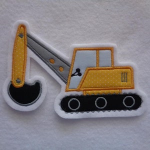 Könnte beinhalten: Gelber und grauer gestickter Bügelaufkleber mit einem Bagger mit schwarzem Schaufel.