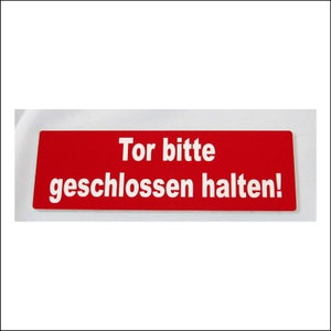 Op de afbeelding: Een rood bord met witte tekst dat "Tor bitte geschlossen halten!" zegt.