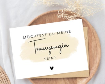 May include: A white card with black text that reads "MÖCHTEST DU MEINE TRAUZEUGIN SEIN?" with a small black heart at the bottom. The text is on a light yellow watercolor background.