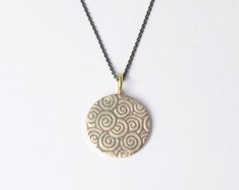 Pendant silver plate with spiral structure and gold eyelet, blackened