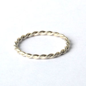 Könnte beinhalten: Ein silberner Ring mit gedrehtem Band.