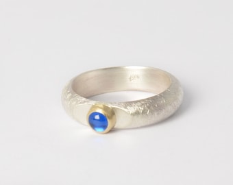 Silver ring with blue spinel in a gold setting