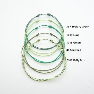 May include: Five different colours of braided cord bracelets in green shades, including Kelly Mix, Seaweed, Green, Lime, and Topiary Green.