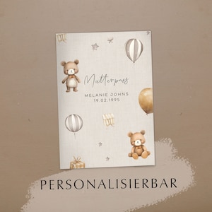 Könnte beinhalten: Ein beiger Babybuchumschlag mit Aquarellillustrationen von Teddybären, Luftballons, Sternen und einer Geschenkbox. Der Text "Mutterpass" ist in eleganter Schrift geschrieben, zusammen mit einem Namen und einem Datum. Das Wort "PERSONALISIERBAR" steht unten.