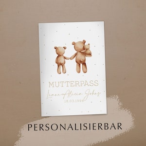Könnte beinhalten: Eine weiße Karte mit einer Illustration einer braunen Teddybär-Familie. Die Karte trägt den Text "Mutterpass" und "Liane Alicia Johns 18.03.1996" in brauner Schrift. Die Karte trägt auch den Text "PERSONALISIERBAR" in brauner Schrift am unteren Rand.