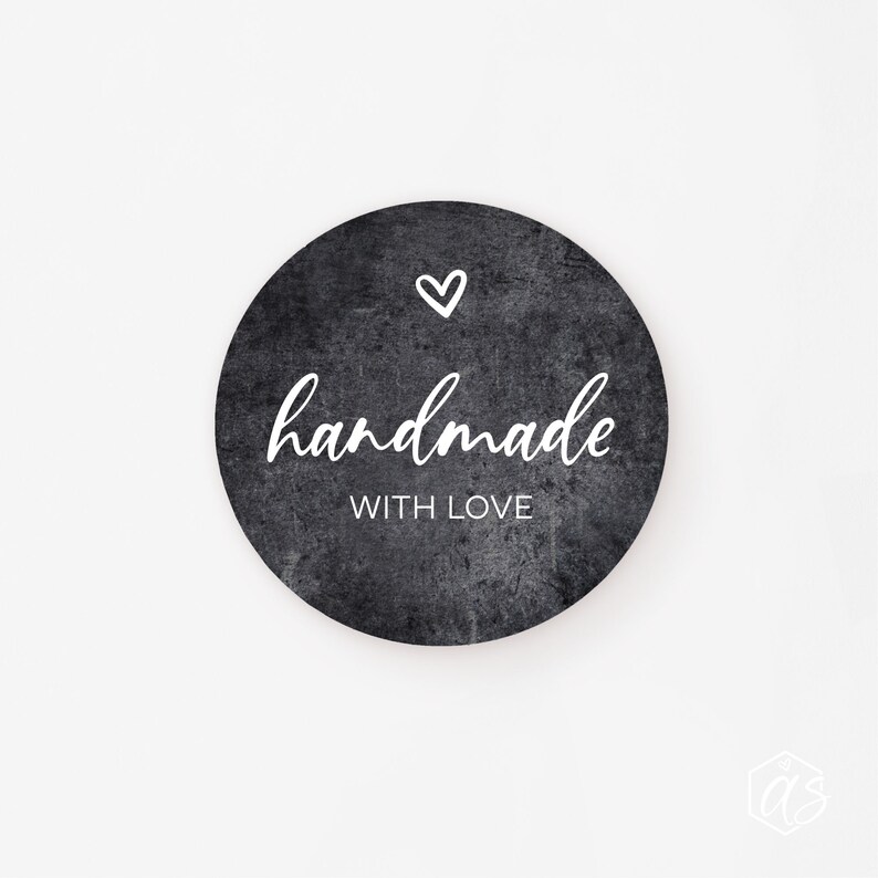 May include: Black and white round sticker with a distressed texture. The sticker says "handmade with love" and has a small heart in the top left corner.