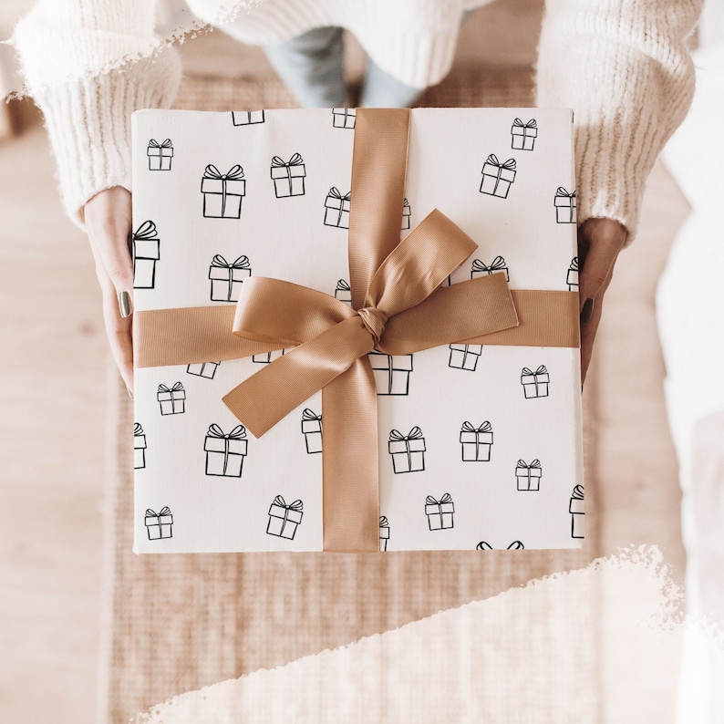 May include: White gift wrap with a brown ribbon and a repeating pattern of black gift boxes.