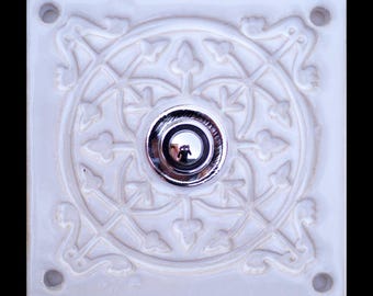 Handmade square ceramic doorbell plate with ornamental design and metal doorbell button.