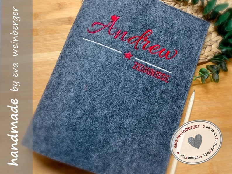 May include: Grey felt folder with red embroidered text "Andrew" and "Zeugnisse" with a red star above the name and below the text. The folder is handmade by eva-weinberger.
