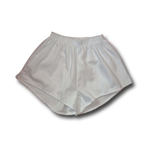 Pode incluir: Shorts esportivos brancos com c&oacute;s el&aacute;stico.