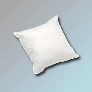 May include: A white pillow with a soft, smooth texture. The pillow is slightly angled and appears to be made of cotton.