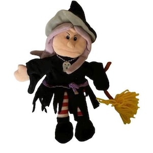 May include: A plush witch doll with a black dress, a pointed hat, and a broom. The doll has a tan face, pink hair, and a silver necklace with a skull pendant. The witch's dress has tattered edges and red and white striped stockings.