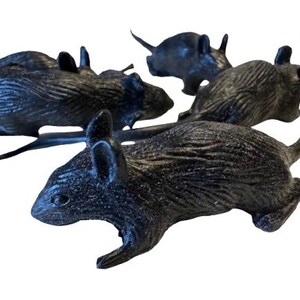 May include: Four black plastic toy rats are arranged on a white background. The rats have detailed fur textures, pointed ears, and long tails. The toys are in various poses, suggesting movement.