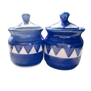 May include: Two blue and white ceramic jars with lids. The jars feature a geometric pattern of white triangles on a blue background.