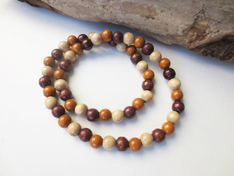 May include: A wooden bead necklace with brown, beige, and purple beads.