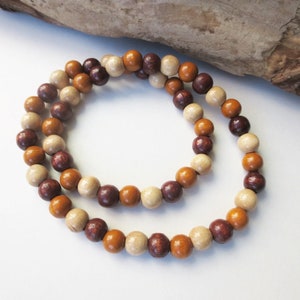 May include: A wooden bead necklace with brown, beige, and purple beads.