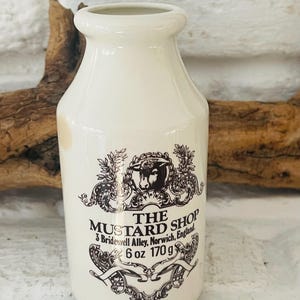 May include: White ceramic mustard jar with a black and white label that reads "THE MUSTARD SHOP 3 Bridewell Alley, Norwich, England. 6 oz 170 g".