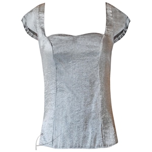 May include: A silver satin top with a square neckline and short sleeves.