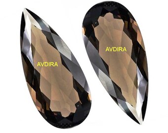 May include: Two pear-shaped smoky quartz gemstones with a faceted cut. The gemstones are a dark brown color with a hint of gray. The text "AVDIRA" is printed on each gemstone.