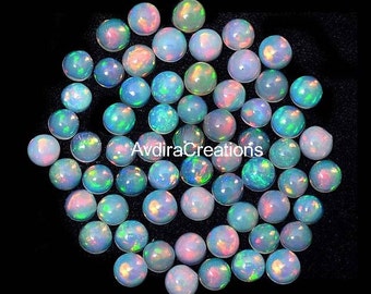May include: A collection of 40 round, iridescent opal cabochons. The opals are a mix of white, blue, green, and pink.