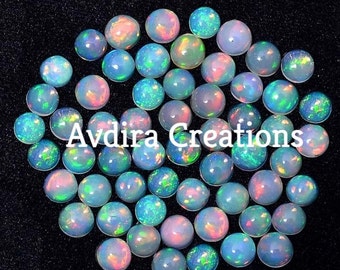 May include: A collection of 40 round, iridescent opal cabochons. The opals are a mix of white, blue, green, and pink colours. The opals are approximately 6mm in diameter.