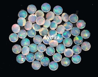 May include: A collection of 30 white opal cabochons, each with a slightly different iridescent sheen. The opals are round and have a smooth, polished surface.