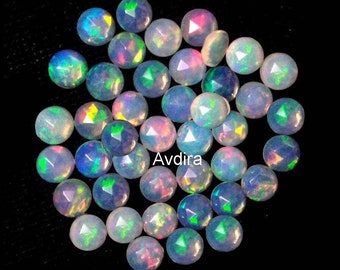 May include: A collection of iridescent opal cabochons, each with a faceted, rounded shape. The opals are a mix of white, blue, green, and pink hues.