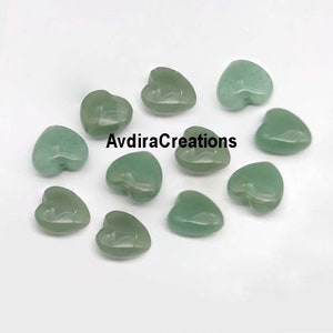 May include: A collection of ten green heart-shaped stones. The stones are smooth and polished, and they have a natural, earthy look.