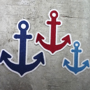 Könnte beinhalten: Drei gestickte Anker-Patches in verschiedenen Größen. Der größte Anker ist blau, der mittlere Anker ist rot und der kleinste Anker ist hellblau.