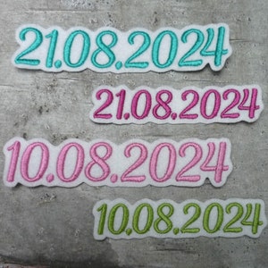 Könnte beinhalten: Vier gestickte Patches mit den Daten 21.08.2024 und 10.08.2024 in verschiedenen Farben: Türkis, Rosa und Grün.