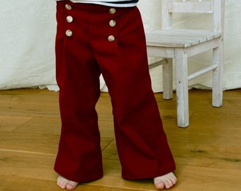 Pantalon enfant en alambic maritime, pantalon marin « Fiete » en rouge-bordeaux foncé, avec jambe large, dossard de marin droit et gauche avec boutons.