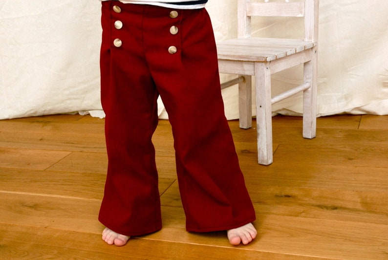 Puede incluir: Pantalones de marinero rojos con botones dorados. Los pantalones tienen una pierna ancha y est&aacute;n hechos de una tela suave y c&oacute;moda.